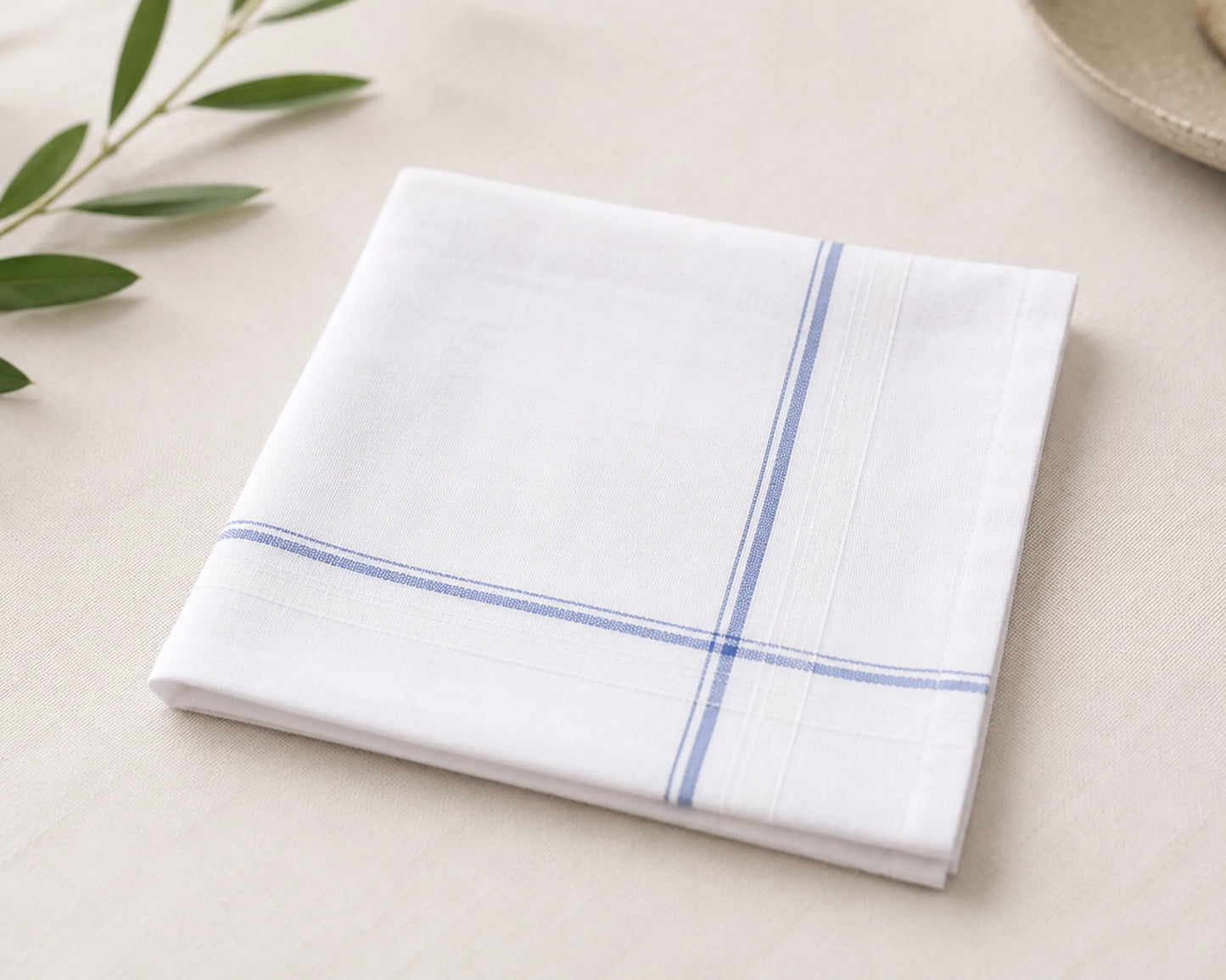 White handkerchief with blue stripes on a light beige surface