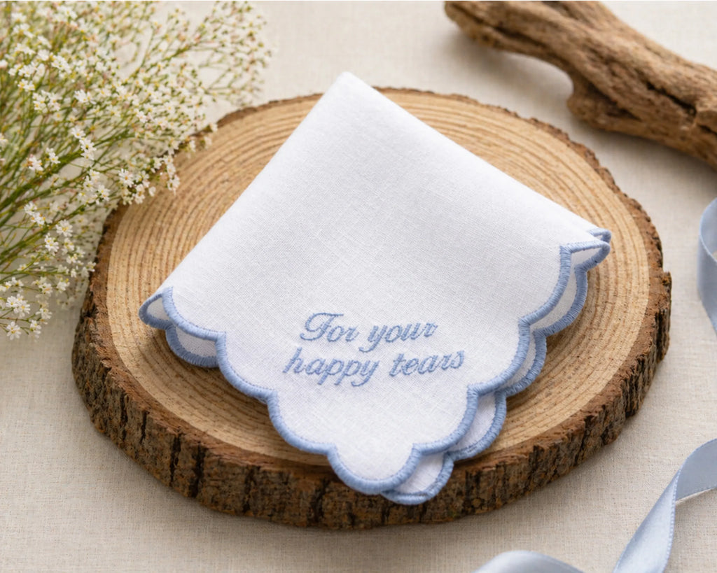 White handkerchief with blue text on a wooden coaster