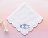 White handkerchief with embroidered initials 'MGS' on a pink background