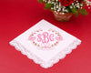 White handkerchief with pink monogram and floral design on a red background