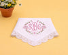 White handkerchief with pink monogram and floral design on a yellow background