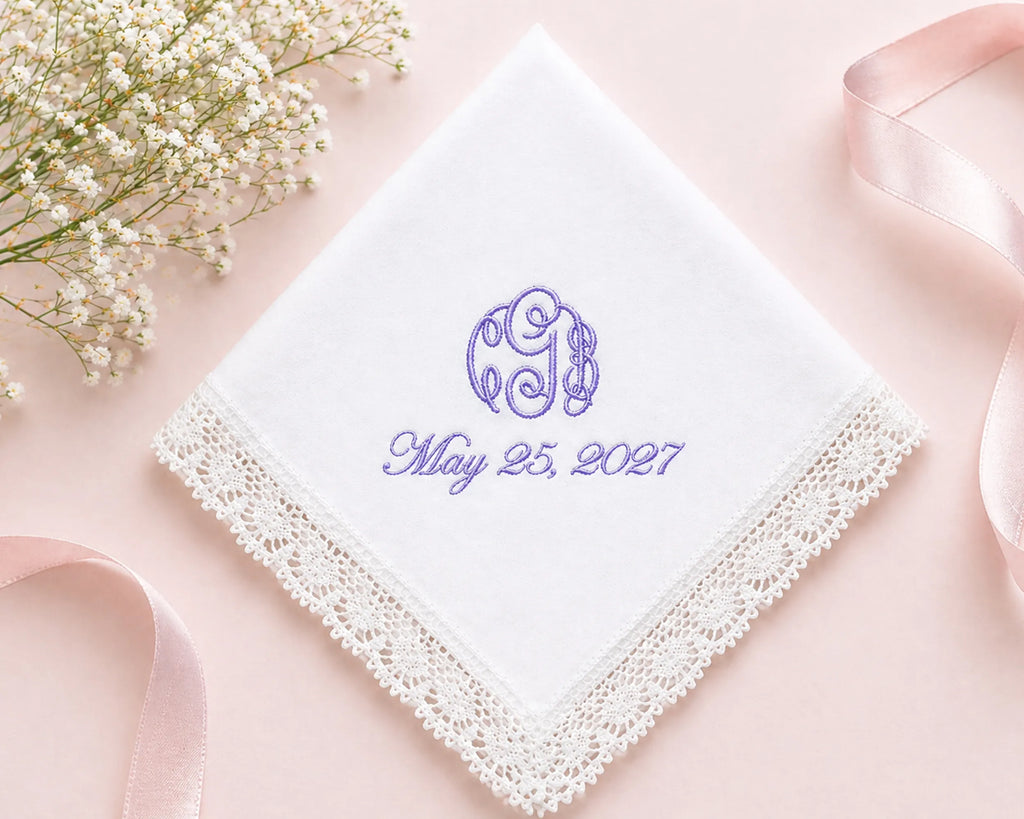White handkerchief with purple monogram and date on a pink background