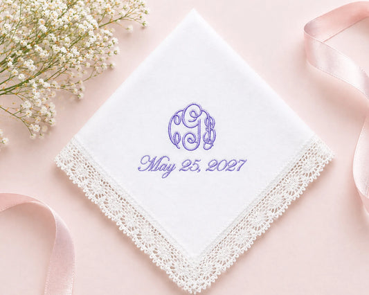 White handkerchief with purple monogram and date on a pink background