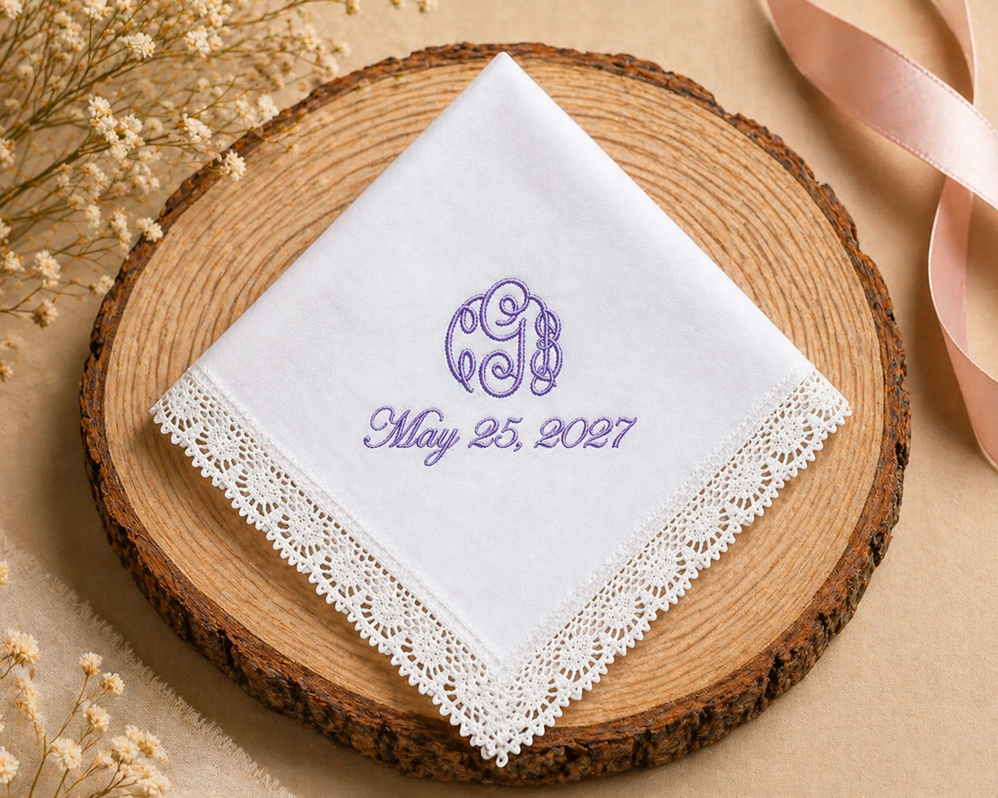 White handkerchief with purple monogram and date on a wooden coaster