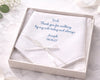 White handkerchief with personalized message in a box on a marble surface