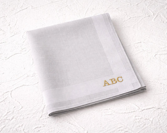 White hanky with 'ABC' embroidery on a textured white surface
