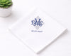 White hanky with blue monogram and date on a white surface with a small plant.
