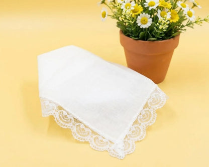 White lace-trimmed handkerchief on a yellow background with a potted plant.
