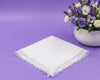 White lace handkerchief on a purple background with a vase of flowers.