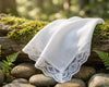 White lace handkerchiefs on a log with a natural background