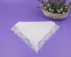 White lace handkerchief on a purple background with a bowl of flowers.