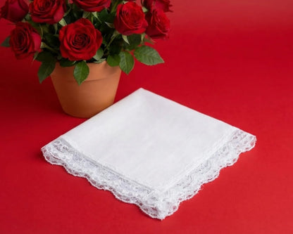 White lace handkerchief on a red background with a potted plant of red roses.
