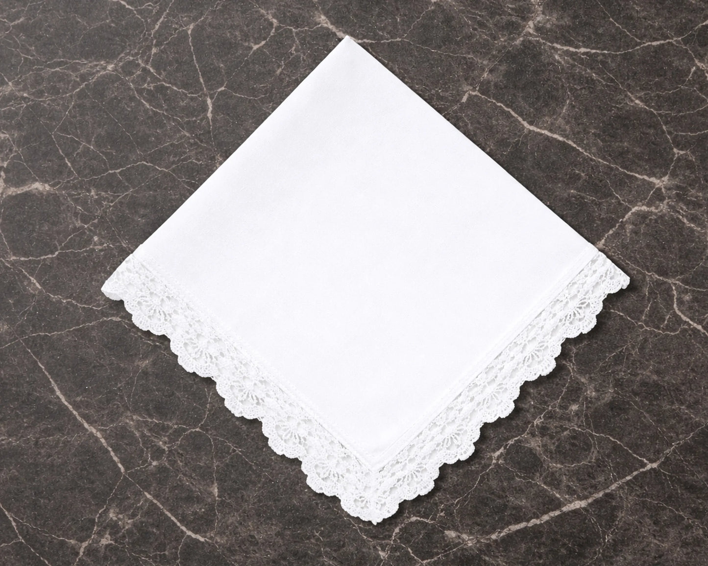 White lace hanky on a dark marble surface