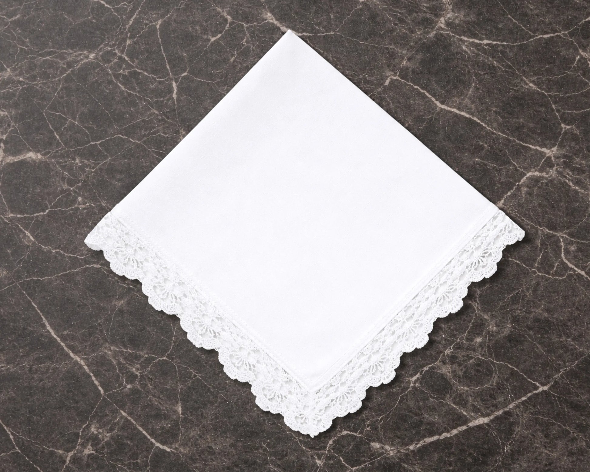 White lace hanky on a dark marble surface