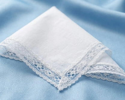 White lace-trimmed handkerchief on a light blue fabric background