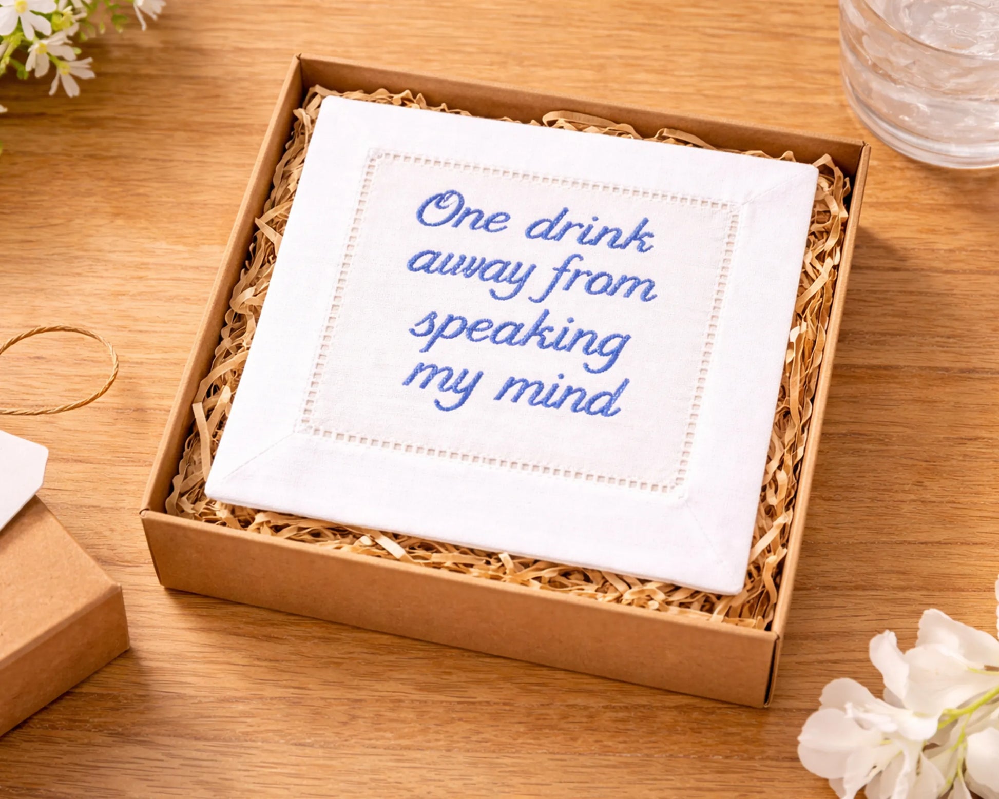 White napkin with blue text in a brown box on a wooden surface