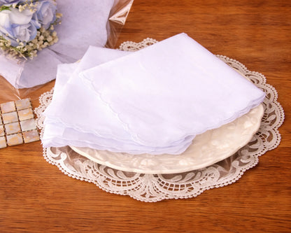 White napkins on a decorative plate with a lace doily on a wooden table.