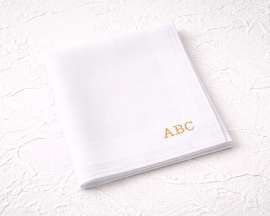 White notebook with 'ABC' in gold on a textured white surface