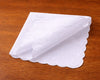 White scalloped-edge hanky on a wooden surface