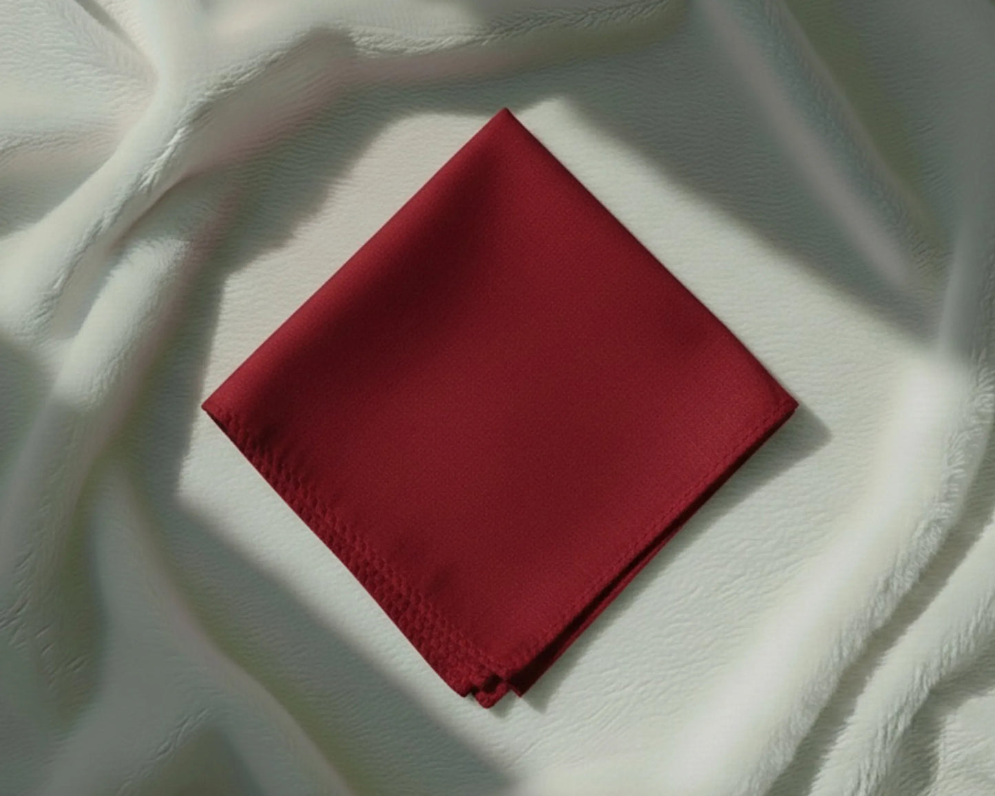 Red fabric square on a textured white surface