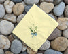 Yellow embroidered handkerchief on a bed of stones