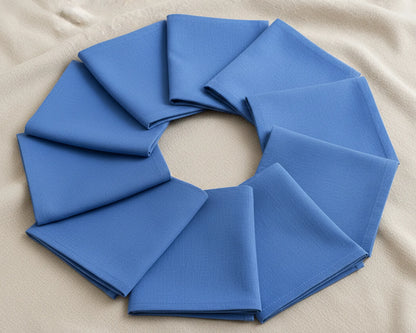 Blue fabric folded into a circular wreath on a beige background