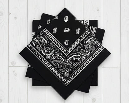 Stack of folded black cotton bandanas with white paisley prints