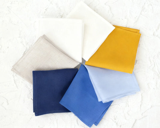 colorful hanky (beige, blue, yellow, and light blue) on a textured white background.