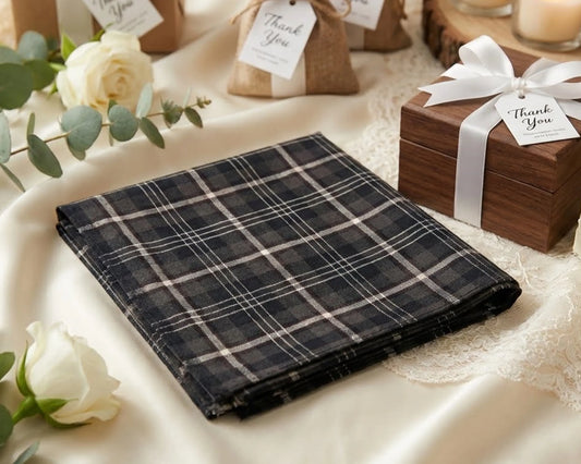 Plaid fabric on a table with flowers and a wooden box.