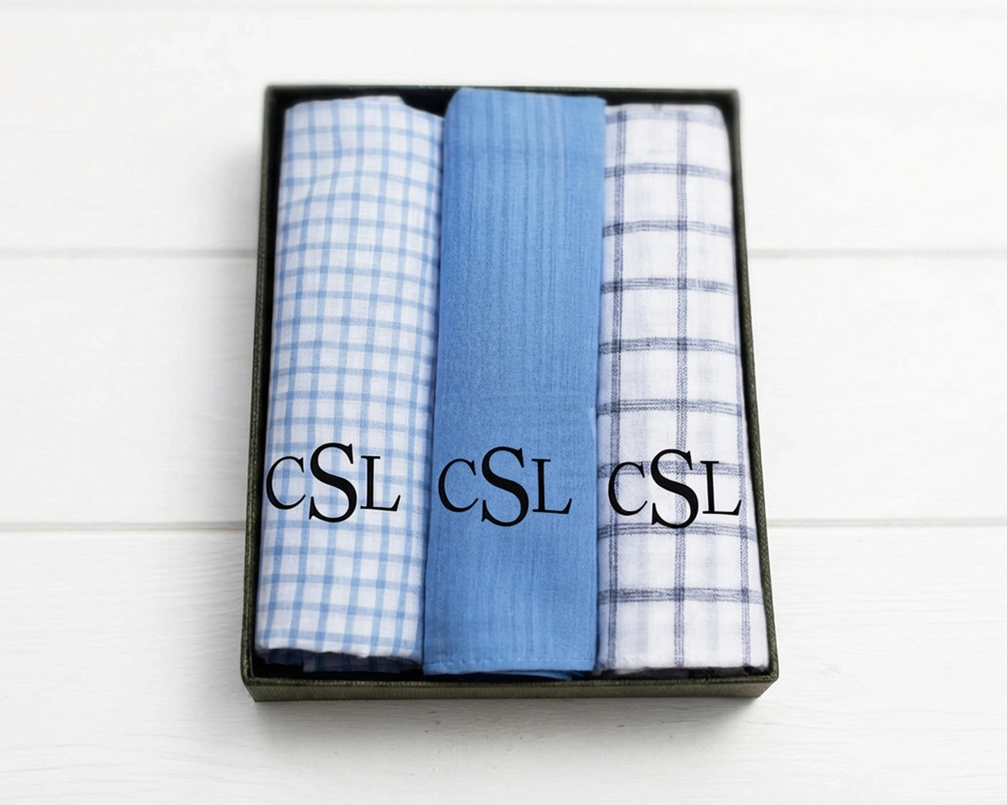 Beige napkin with embroidered design and text on a white wooden surface