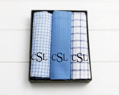Beige napkin with embroidered design and text on a white wooden surface