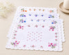 Set of floral placemats on a beige surface with a decorative edge.