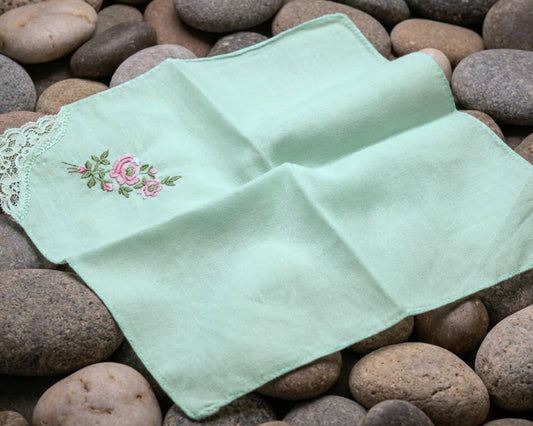 Two green embroidered handkerchiefs on a bed of stones