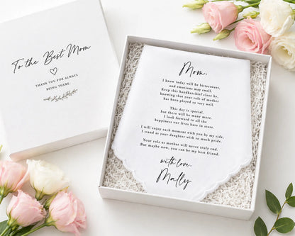 hanky in a box with a message for 'Mom' surrounded by pink flowers on a white surface