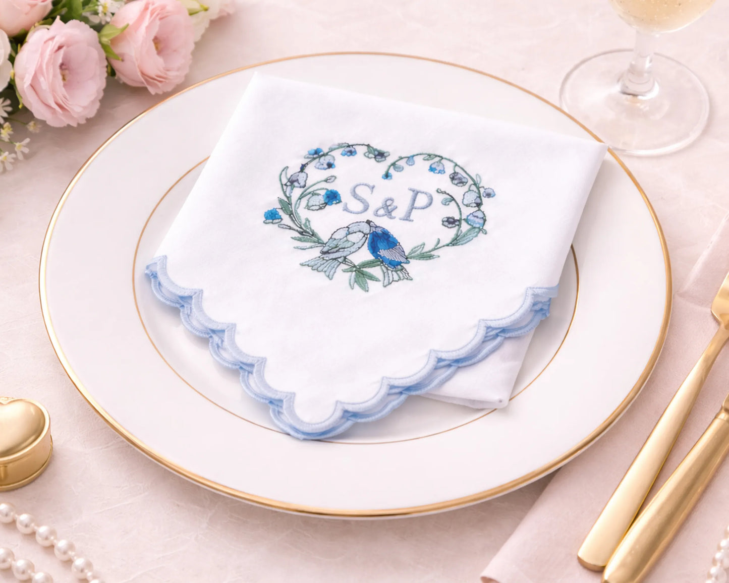 hanky with 'S&P' design on a plate with floral decorations and gold cutlery.