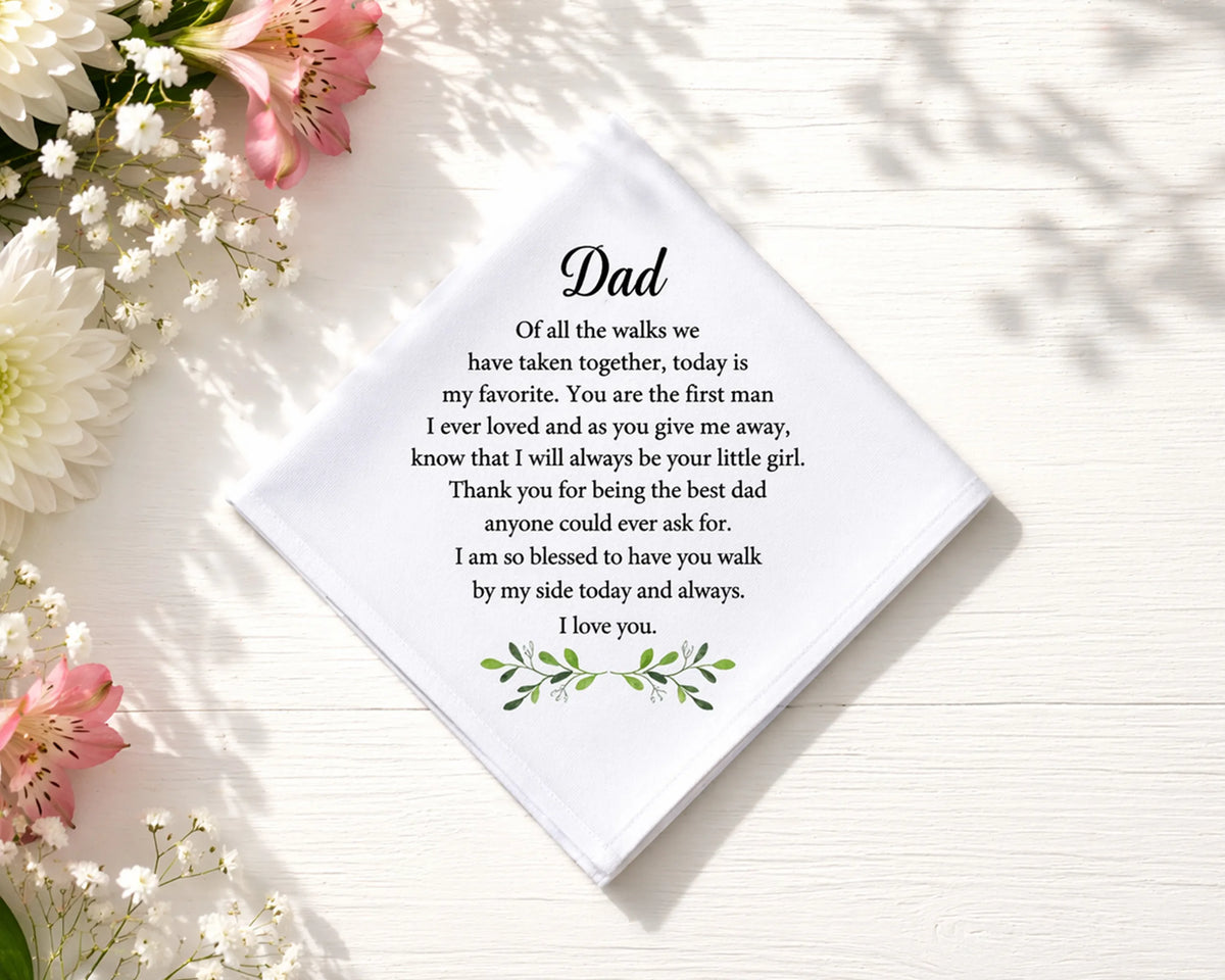 hanky with a message for Dad surrounded by flowers on a light surface