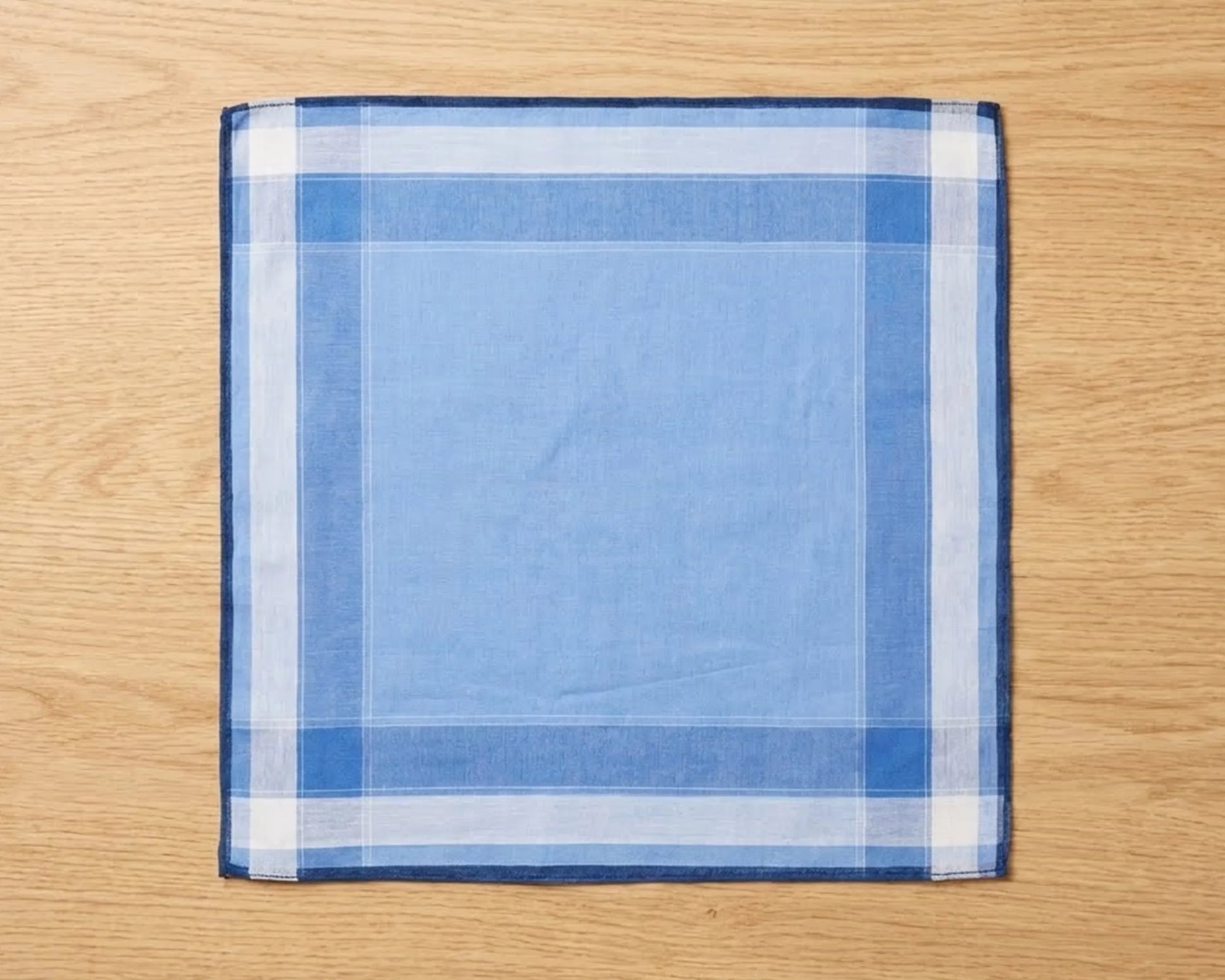 Blue and white checkered pocket square on a wooden surface