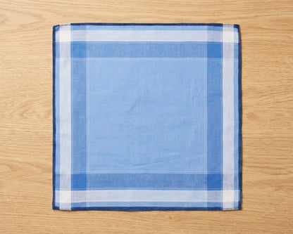 Blue and white checkered pocket square on a wooden surface