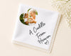 White handkerchief with photo of an elderly woman and a child, and text 'A Cuddle From Heaven' on a beige background.