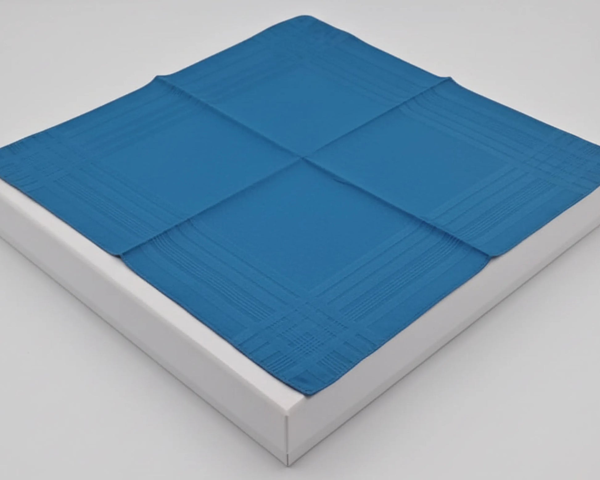 Blue mattress cover on a white mattress against a gray background