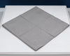 Gray textured square mat on a white surface with a dark blue background