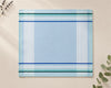 Placemat with blue and green striped pattern on a beige background