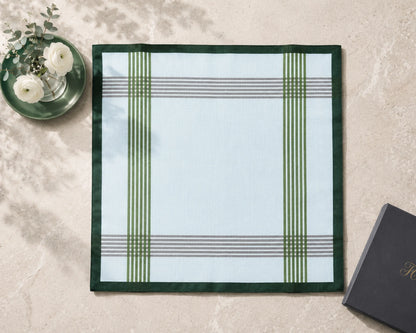 Plaid placemat on a marble surface with a black book and white flowers.