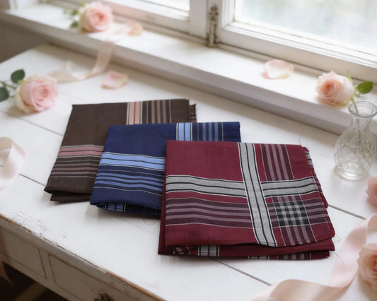 Folded fabric hanky on a white surface with flowers in the background