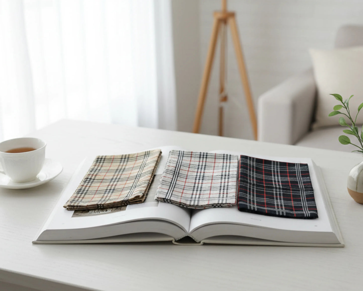 Open book with plaid fabric samples on a white surface