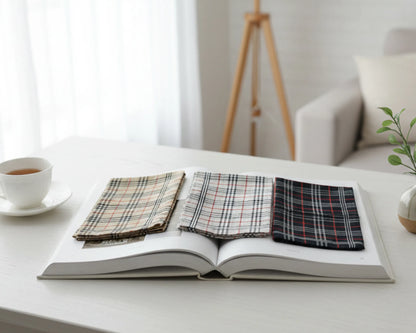 Open book with plaid fabric samples on a white surface