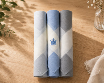Three rolled-up HANKY with a geometric pattern on a wooden surface.