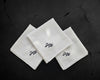 Three white folded cotton handkerchiefs with custom black script monograms 