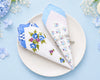 Decorative folded napkins with floral patterns on a light blue background