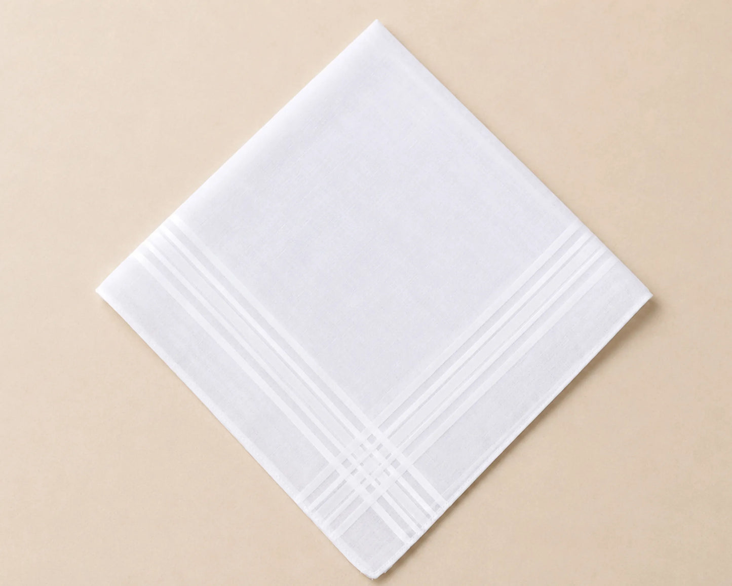 White hanky with subtle pattern on a beige background
